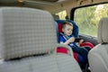 Portrait of a bored little boy sitting in a car seat. Safety of transportation of children Royalty Free Stock Photo