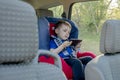 Portrait of a bored little boy sitting in a car seat. Safety of transportation of children Royalty Free Stock Photo