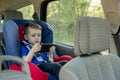 Portrait of a bored little boy sitting in a car seat. Safety of transportation of children Royalty Free Stock Photo