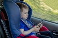 Portrait of a bored little boy sitting in a car seat. Safety of transportation of children Royalty Free Stock Photo