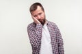 Portrait of bored young bearded man leaning on hand with dull lazy face expression. white background Royalty Free Stock Photo