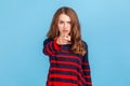 Portrait of bossy serious woman wearing striped casual style sweater pointing finger to camera