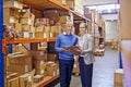 Portrait, boxes and man with woman, clipboard and documents with shipping form and import. Tablet, warehouse and export Royalty Free Stock Photo