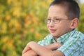 Portrait of boy with arms across in fall park Royalty Free Stock Photo