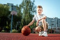 Portrait of a boy with a basketball on a basketball court. The concept of a sports lifestyle, training, sport, leisure, vacation Royalty Free Stock Photo