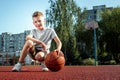 Portrait of a boy with a basketball on a basketball court. The concept of a sports lifestyle, training, sport, leisure, vacation Royalty Free Stock Photo