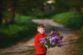 Portrait of a boy with a bouquet of lilacs .