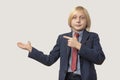 Portrait of a boy in a business suit pointing at something with his hand Royalty Free Stock Photo