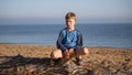 Portrait of a boy. A child is sitting on a log lying on the beach Royalty Free Stock Photo