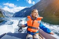 Portrait of boy close up driving the motorboat, Norway. He is enjoying the moment. Royalty Free Stock Photo