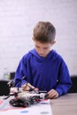 Portrait of a boy constructing a robot at school lesson. Robotics