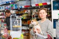 Portrait of a boy with dog in petshop, man on background