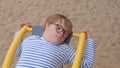 Portrait boy down syndrome glasses child swing lies Restoring strength