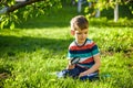 portrait of the boy in a garden, considers plants through a magnifying glass. Royalty Free Stock Photo