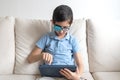 Portrait of boy in glasses with patch for glasses. Boy with tablet. Treat lazy eye, amblyopia, strabismus.  Remote learning. Dista Royalty Free Stock Photo