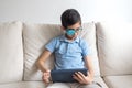 Portrait of boy in glasses with patch for glasses. Boy with tablet. Treat lazy eye, amblyopia, strabismus.  Remote learning. Dista Royalty Free Stock Photo