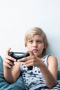 Boy holding joystick gaming controller in hands, playing video game at home. Royalty Free Stock Photo