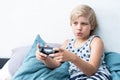 Boy holding joystick gaming controller in hands, playing video game at home. Royalty Free Stock Photo