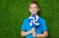 Portrait of a boy holding pinwheel over grass Royalty Free Stock Photo