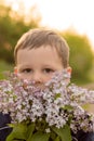 Portrait of a boy with lilac. bouquet of purple lilac in children`s hands. hands holding a purple lilac flowers bouquet in meadow Royalty Free Stock Photo