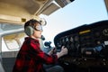 Portrait of boy looking focused and serious, sitting in cockpit of small airplane Royalty Free Stock Photo