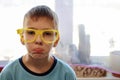 Portrait of a boy making faces in funny yellow glasses made on a 3d printer Royalty Free Stock Photo