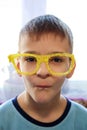 Portrait of a boy making faces in funny yellow glasses made on a 3d printer Royalty Free Stock Photo