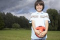 Portrait of boy in meadow with football looking away Royalty Free Stock Photo