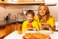 Portrait of boy and mother ready to eat pizza