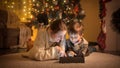 Portrait of boy with mother warm wool sweater lying on floor and using digital tablet computer on Christmas eve at house Royalty Free Stock Photo