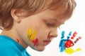 Portrait of a boy with painted face on a background of hand printsPortrait of a boy with painted face on background of hand prints Royalty Free Stock Photo