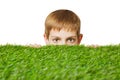 Portrait of a boy peeping out through grass