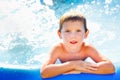 Portrait of a boy in the pool. A happy child swims in an inflatable pool in the garden of letnis on a sunny day Royalty Free Stock Photo