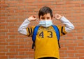 Boy removing or putting on a surgical face mask Royalty Free Stock Photo