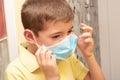 Boy removing a surgical face mask Royalty Free Stock Photo