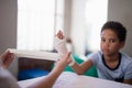 Portrait of boy sitting at table while female therapist wrapping bandage on hand Royalty Free Stock Photo