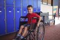 Portrait of boy sitting on wheelchair in corridor Royalty Free Stock Photo