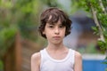 Portrait of a boy in a sleeveless shirt.