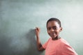 Portrait of boy standing by chalkboard