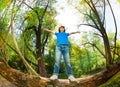 Portrait of boy standing on fallen tree stem