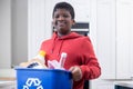 Portrait Of Boy Standing In Kitchen At Home Carrying Recycling Bin Royalty Free Stock Photo