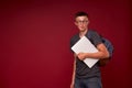 Portrait of a boy student with a backpack and laptop in his hands smiling on a red background. funny positive teenager is a high Royalty Free Stock Photo