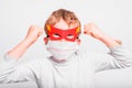 Portrait of boy in superhero mask with his mouth covered with a medical mask to protect himself from viral infections and diseases