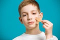 Portrait of a boy tearing off adhesive plaster from his che Royalty Free Stock Photo