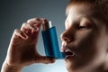 Portrait of a boy using an asthma inhaler to treat inflammatory diseases, shortness of breath. The concept of treatment for cough Royalty Free Stock Photo