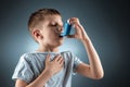 Portrait of a boy using an asthma inhaler to treat inflammatory diseases, shortness of breath. The concept of treatment for cough Royalty Free Stock Photo