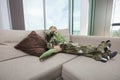 Portrait of boy wearing dinosaur costume relaxing on sofa at home