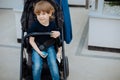 Portrait of boy 3 years old in baby carriage, looks at camera and smiles. childhood and carelessness