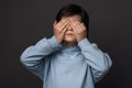 Portrait of boy 10-12 years old covering his eyes with hands. Facial expression concept. Studio shot, white background Royalty Free Stock Photo