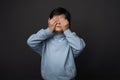 Portrait of boy 10-12 years old covering his eyes with hands. Facial expression concept. Studio shot, white background Royalty Free Stock Photo